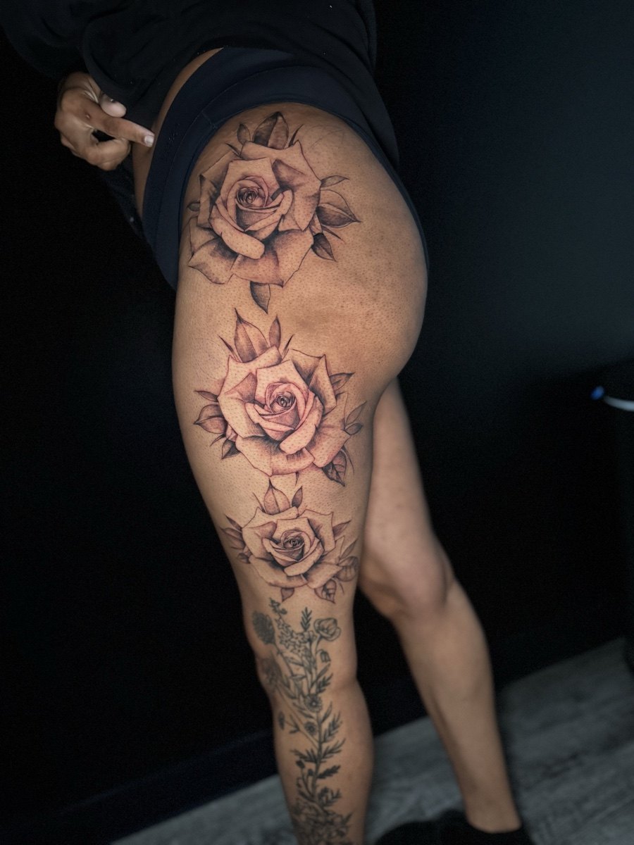 Color portrait and floral tattoo sleeve on an upper arm.