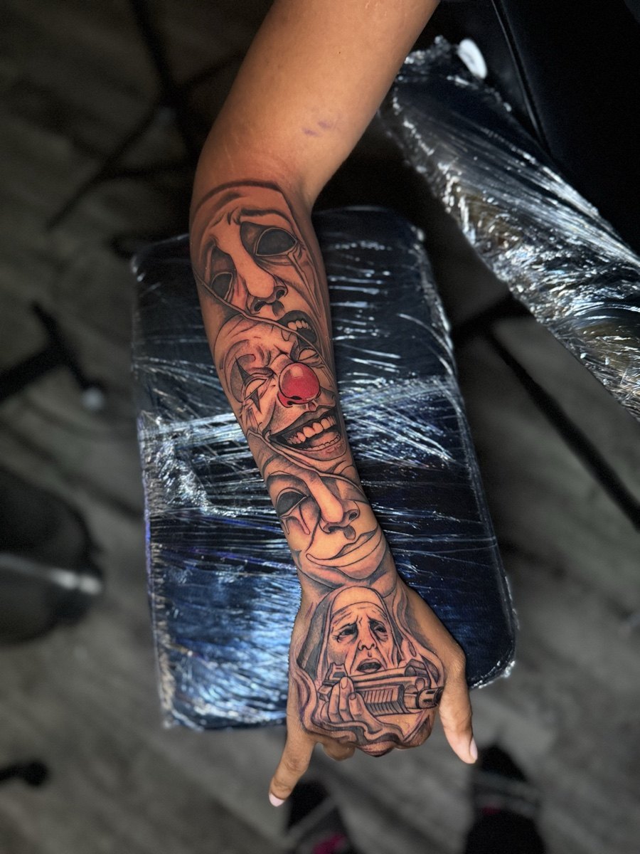 Full-color illustrative tattoo sleeve extending onto the hand.